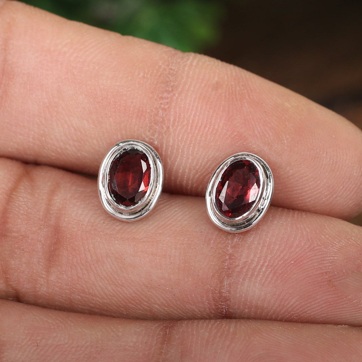 Natural garnet drop earrings worn on ear, gift styling with neutral background