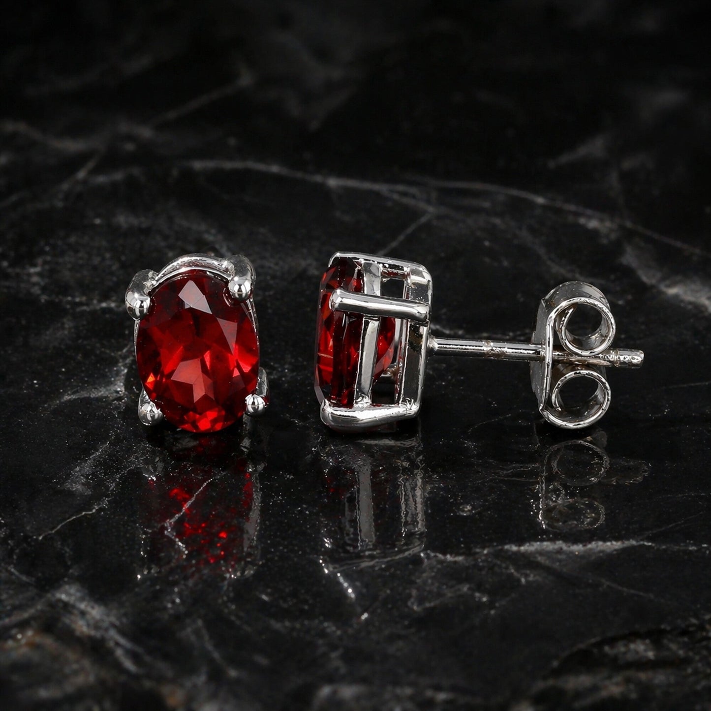 Side view of garnet dangle earrings with sterling silver bezel and post