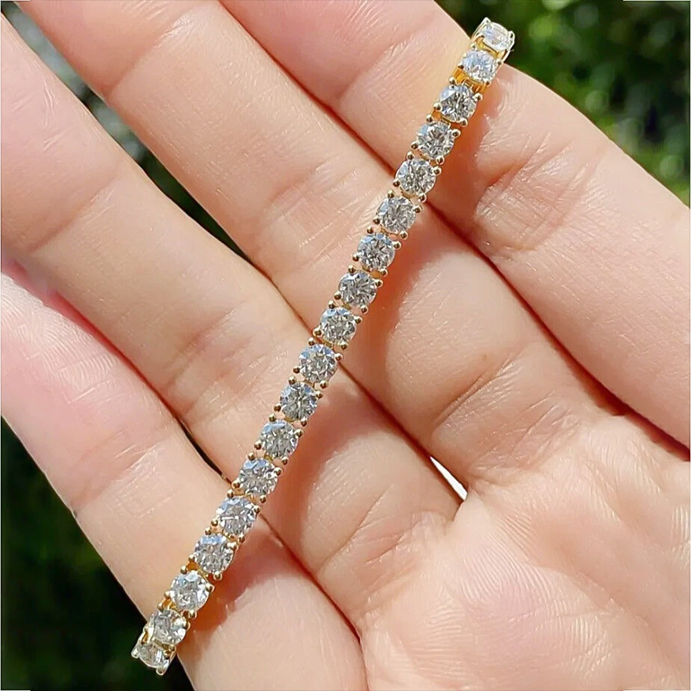 Pattern of round brilliant diamonds along yellow gold tennis bracelet links