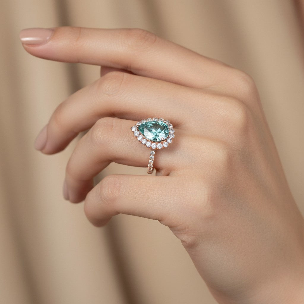 GEMHUB & CO. 4.70 Ct blue pear cut moissanite solitaire ring with diamond halo and band, set in gold vermeil.