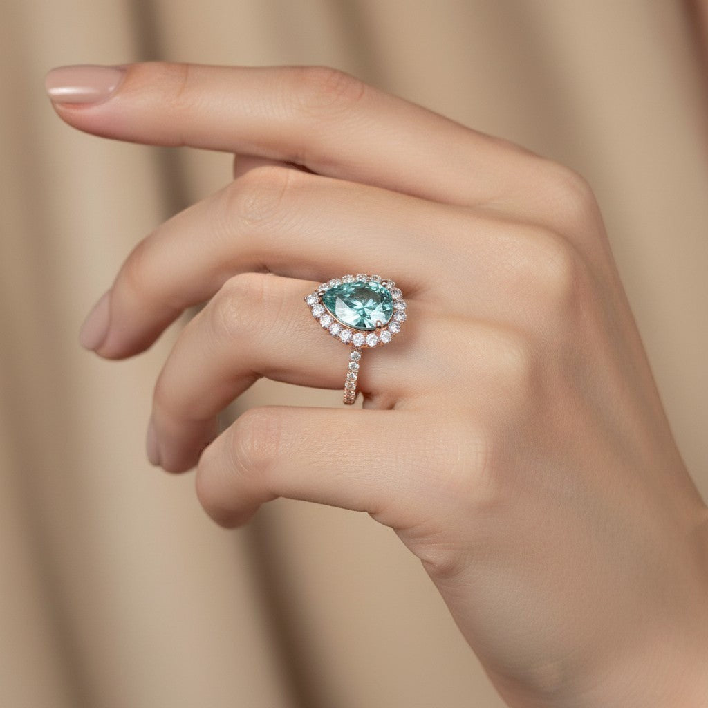 GEMHUB & CO. 4.70 Ct blue pear cut moissanite solitaire ring with diamond halo and band, set in gold vermeil.