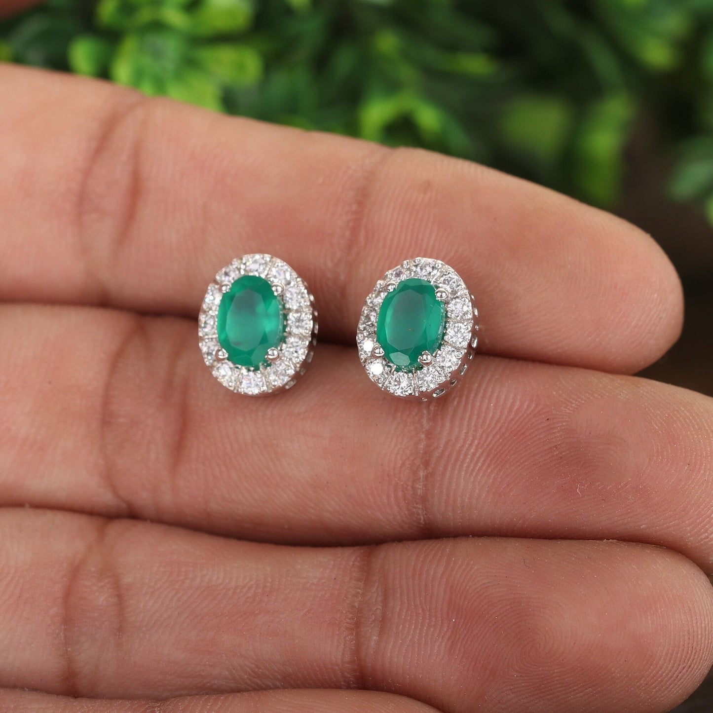 Green emerald cut earrings worn on ear, evening jewellery styling