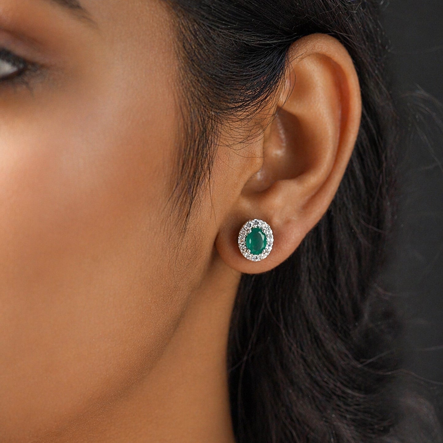 Pair of emerald cut green gemstone earrings showing step facets and vivid colour