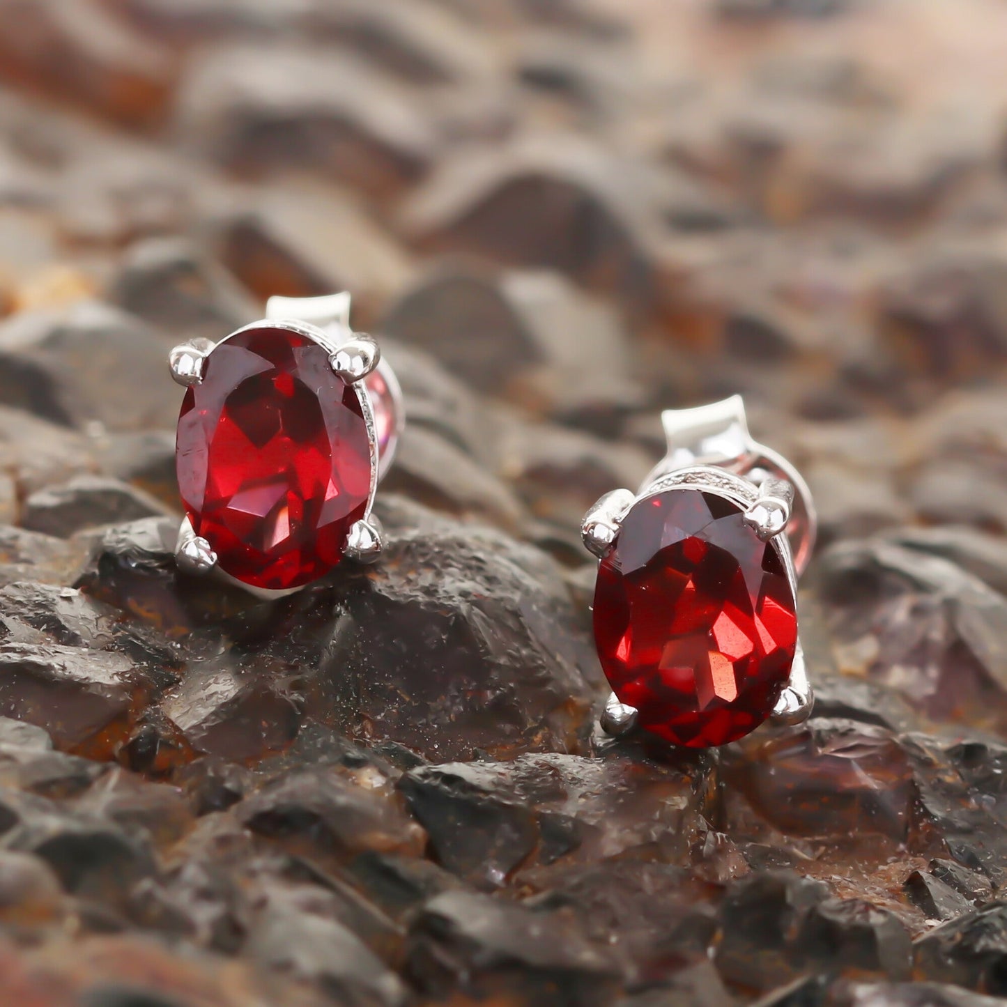 Close-up of single garnet earring showing facets and rich pomegranate hue