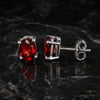 Side view of garnet dangle earrings with sterling silver bezel and post