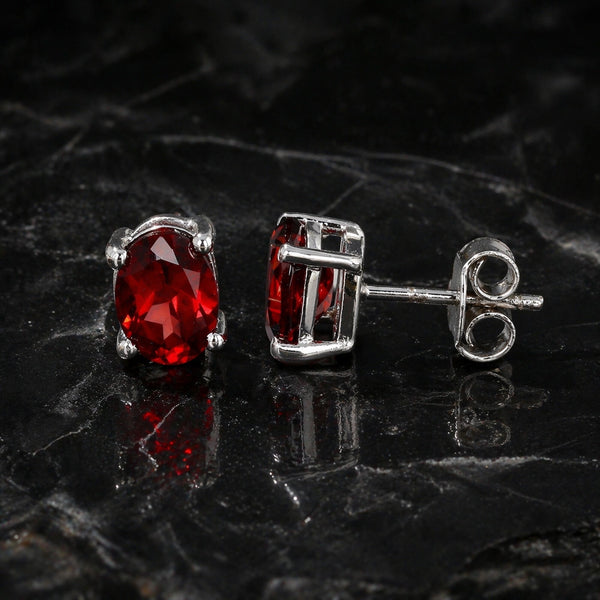 Side view of garnet dangle earrings with sterling silver bezel and post