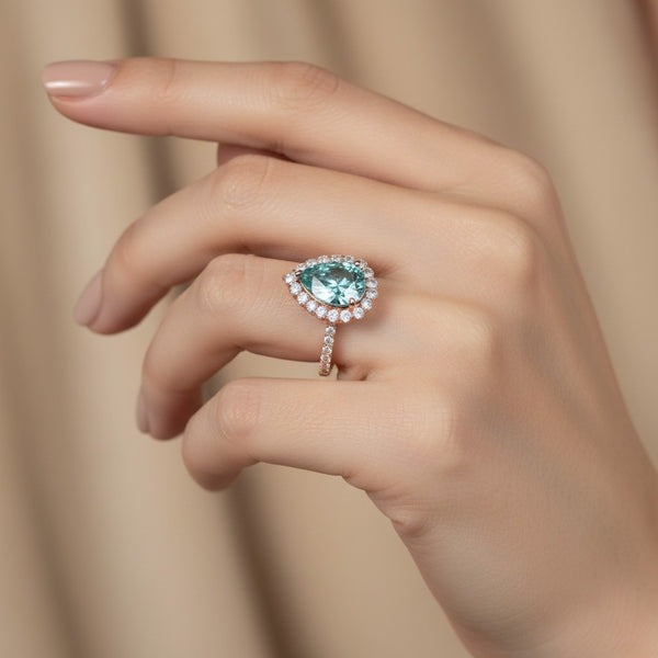 GEMHUB & CO. 4.70 Ct blue pear cut moissanite solitaire ring with diamond halo and band, set in gold vermeil.
