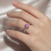 GEMHUB & CO. 1.3ct round pink moissanite solitaire ring with small accent stones on a silver band.