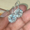 GEMHUB & CO. 10 Ct round cut white moissanite dangler earrings in 18K gold vermeil over 925 sterling silver.
