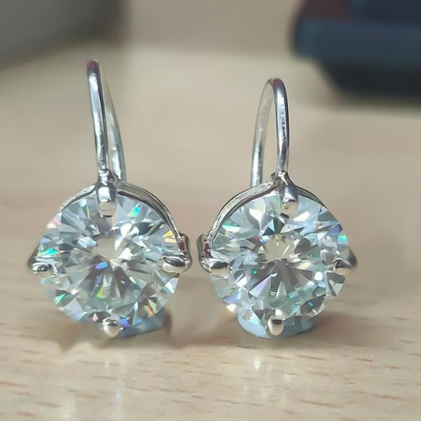 GEMHUB & CO. 10 Ct round cut white moissanite dangler earrings in 925 sterling silver with gold vermeil.