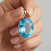 135 ct Natural Blue Topaz Oval Pendant in 925 Sterling Silver – held in hand for scale (AI)
