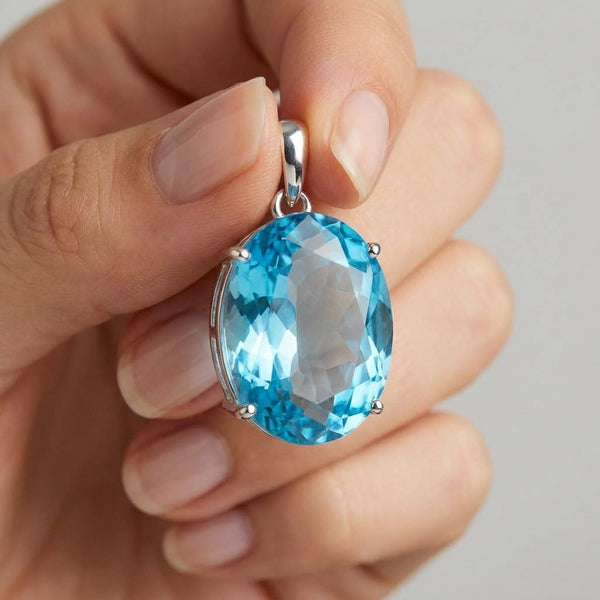 135 ct Natural Blue Topaz Oval Pendant in 925 Sterling Silver – held in hand for scale (AI)
